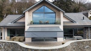 Image of an aluminium awning above the patio of a countryside home.
